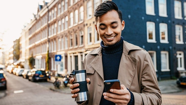 Businessman viewing the Commercial Rewards Card, one of our commercial credit cards, on a smartphone. 